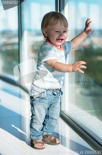 Image of Happy baby boy near big window