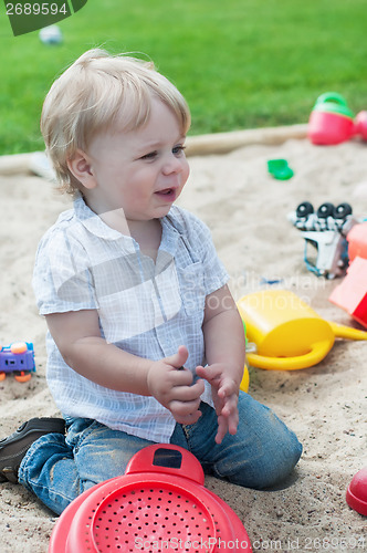 Image of Small boy playing in sandpit