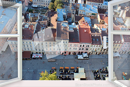 Image of opened window to the roofs of city