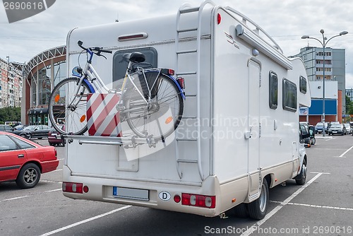 Image of camper with bicycle in city