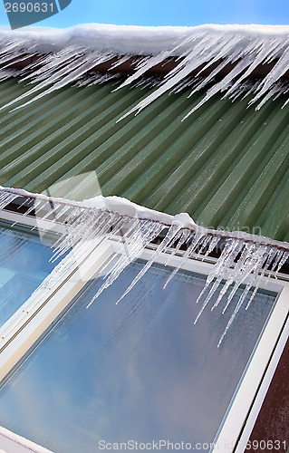 Image of Many icicles hang on chalet´s roof 