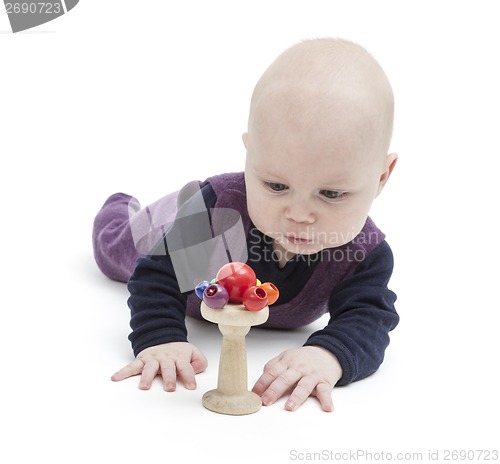 Image of baby looking at wooden toy