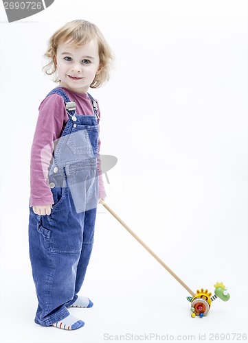 Image of preschooler with toy standing in light background