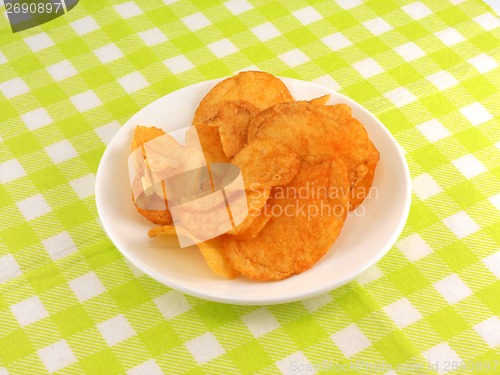 Image of Potato chips falling in the white plate