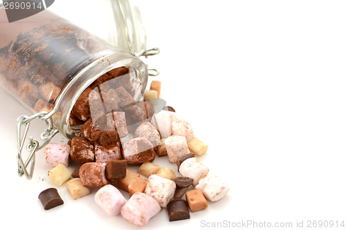 Image of Cocoa and hot chocolate toppings spill from a glass jar