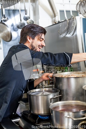 Image of Chef stirring a huge pot of stew or casserole