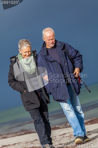 Image of happy elderly senior couple walking on beach