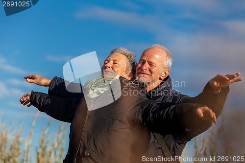 Image of Elderly couple embracing and celebrating the sun