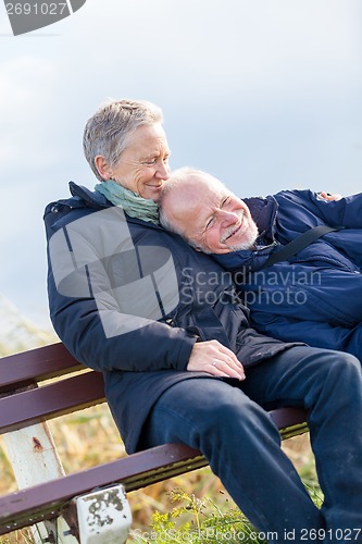 Image of happy senior couple relaxing together in the sunshine