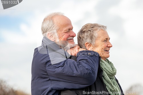 Image of happy elderly senior couple walking on beach