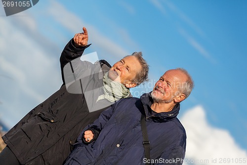 Image of happy elderly senior couple walking on beach
