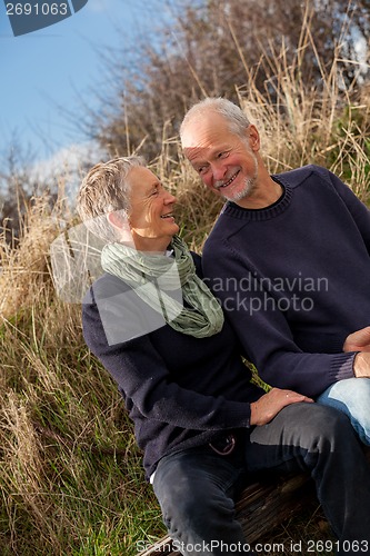 Image of happy senior couple relaxing together in the sunshine