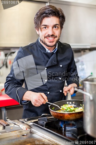 Image of Chef cooking a vegetables stir fry over a hob