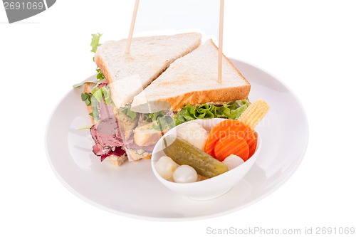 Image of Delicious pastrami club sandwich and pickles