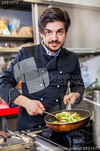 Image of Chef cooking a vegetables stir fry over a hob