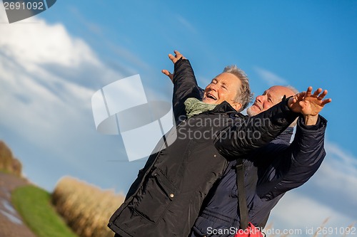 Image of Elderly couple embracing and celebrating the sun