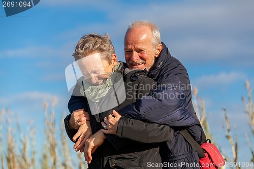 Image of Elderly couple embracing and celebrating the sun