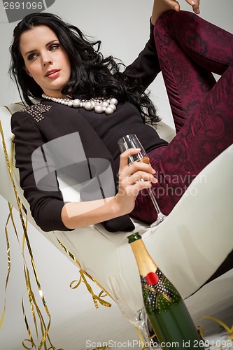 Image of Seductive brunette holding a glass of champagne