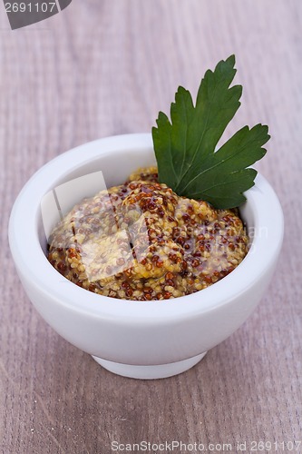 Image of fresh yellow mustard in white bowl with parsley decorated