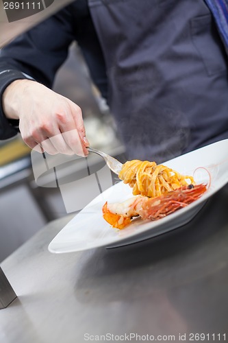 Image of Chef plating up seafood pasta