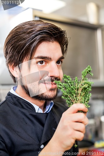Image of Chef checking the freshness of a bunch of herbs