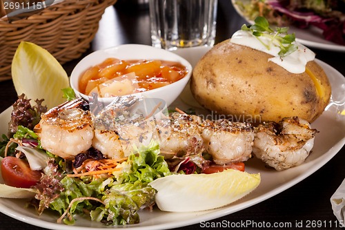 Image of Grilled prawns with endive salad and jacket potato