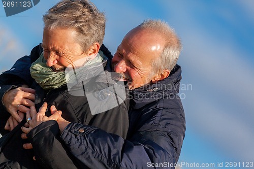 Image of Elderly couple embracing and celebrating the sun