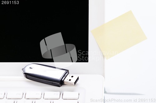 Image of notebook laptop with post it memo and usb stick 