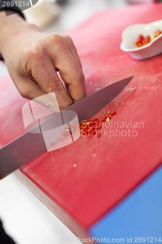 Image of Chef dicing red hot chili peppers