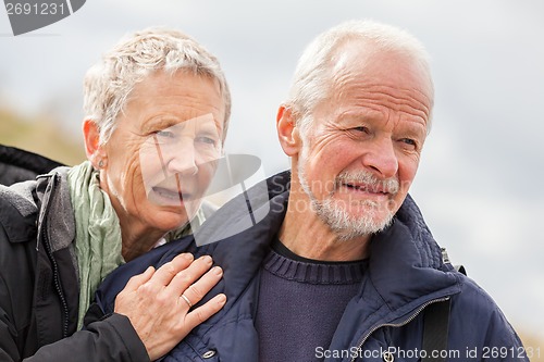 Image of happy elderly senior couple walking on beach