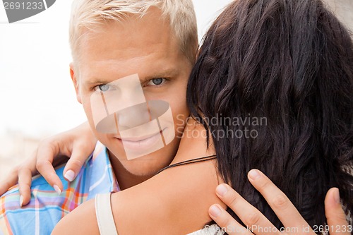 Image of Romantic handsome man hugging his girlfriend