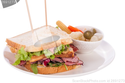 Image of Delicious pastrami club sandwich and pickles