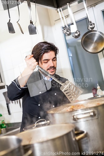 Image of Chef stirring a huge pot of stew or casserole