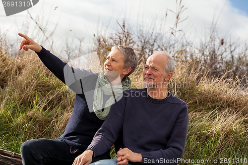 Image of happy senior couple relaxing together in the sunshine