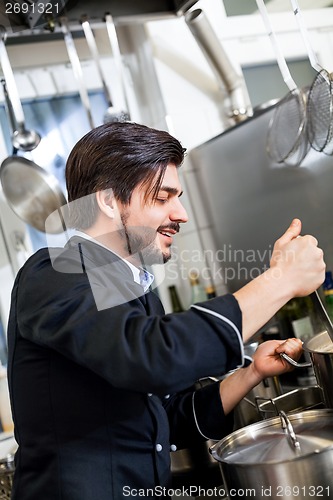 Image of Chef stirring a huge pot of stew or casserole