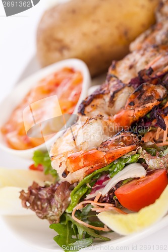 Image of Grilled prawns with endive salad and jacket potato