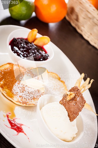 Image of tasty sweet pancakes with vanilla icecream and topping