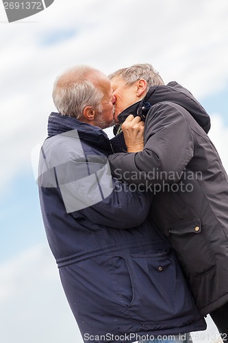 Image of happy elderly senior couple walking on beach