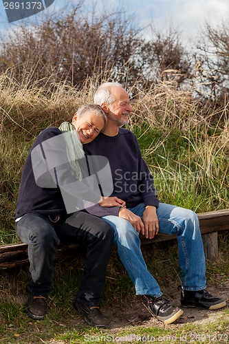 Image of happy senior couple relaxing together in the sunshine