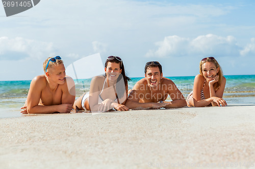 Image of young happy friends havin fun on the beach