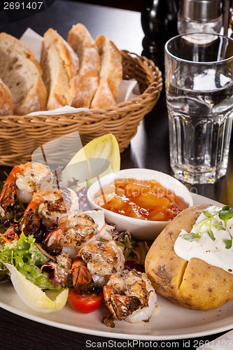 Image of Grilled prawns with endive salad and jacket potato