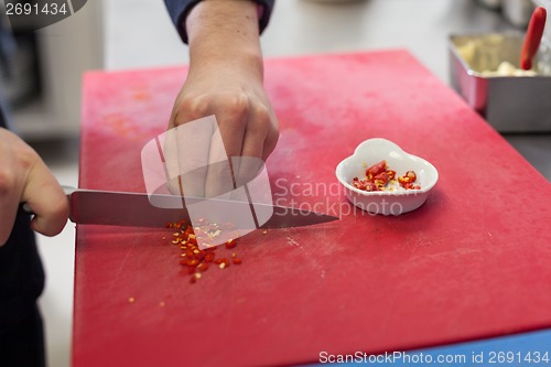 Image of Chef dicing red hot chili peppers