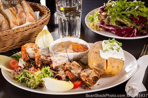 Image of Grilled prawns with endive salad and jacket potato