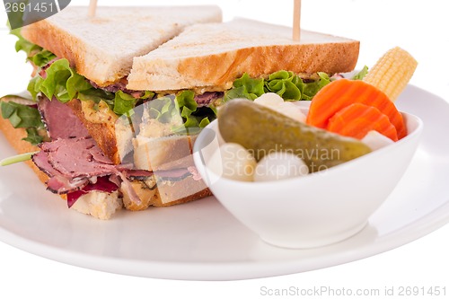 Image of Delicious pastrami club sandwich and pickles