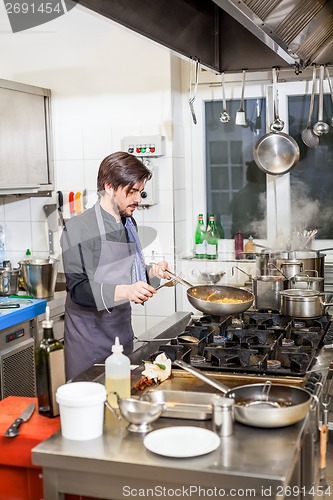 Image of Chef cooking a vegetables stir fry over a hob