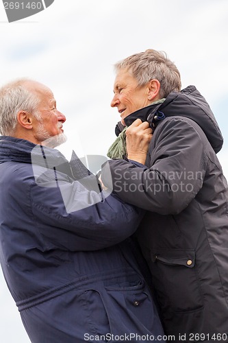 Image of happy elderly senior couple walking on beach