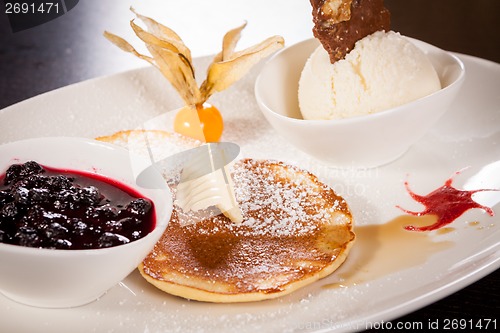 Image of tasty sweet pancakes with vanilla icecream and topping