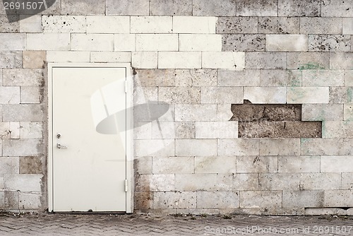 Image of metal door and brik wall