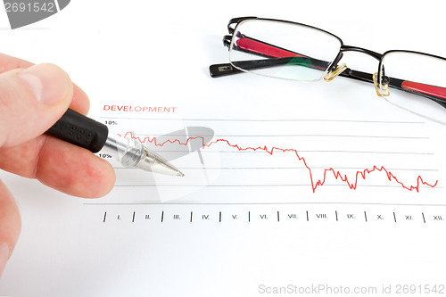 Image of men analyzing business graph with glasses in the background