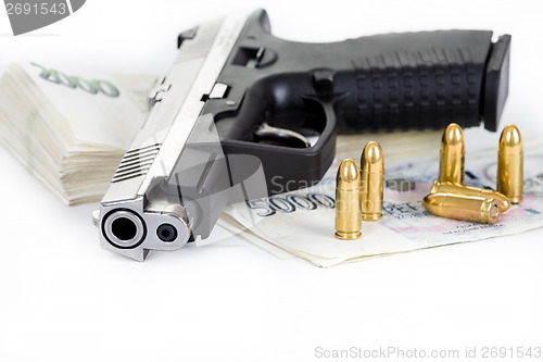 Image of gun with bullet and czech banknotes